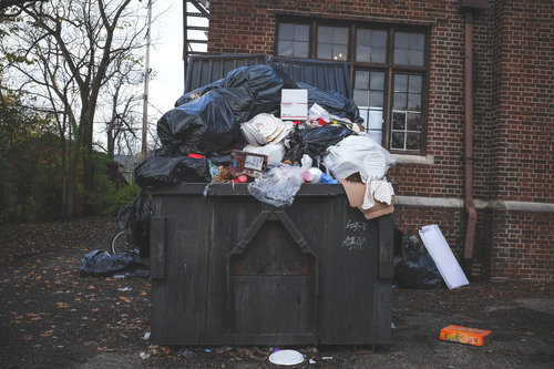 Een overvolle vuilcontainer met restafval.